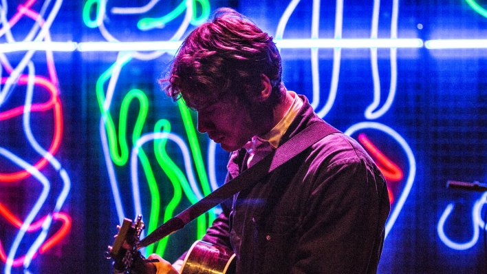 Boris Van Severen mit Gitarre vor Neonleuchtschlangen