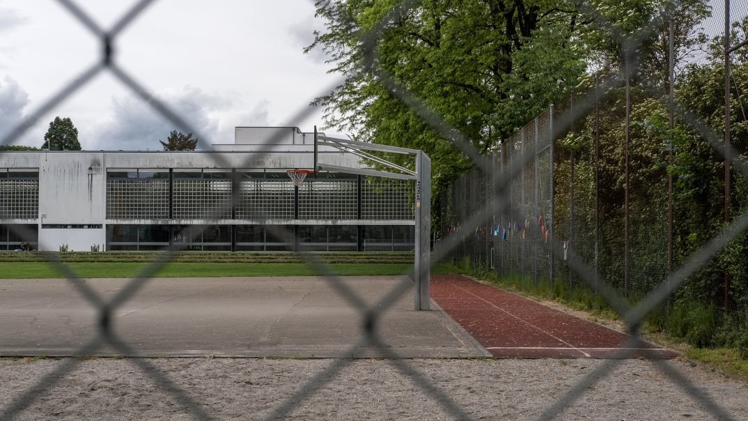 Blick durch ein Gitter auf einen Sportplatz