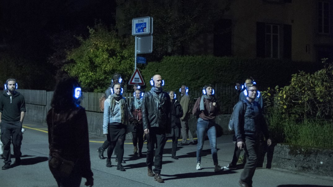 Menschen spazieren im Dunkeln mit Kopfhörern 