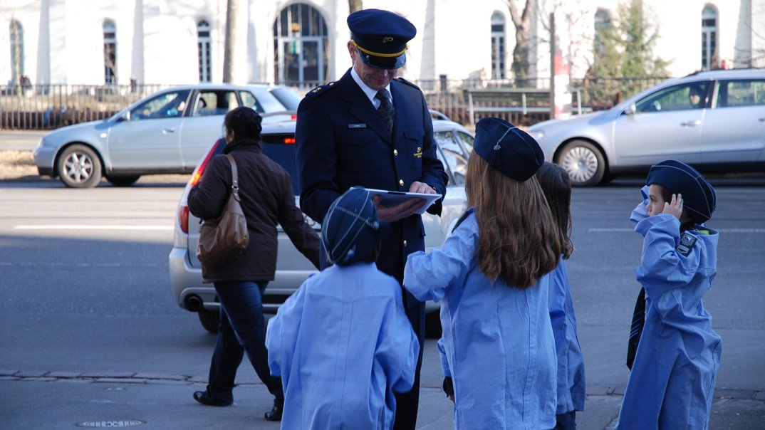 Kinder in Polizeiuniform und ein erwachsener Polizist