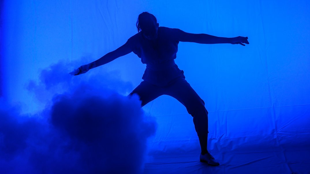 Eine Person steht im blauen Nebel