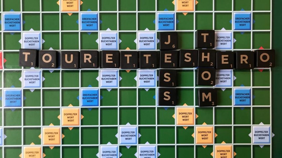 Die Worte Touretteshero, Jess und Thom auf einem Scrabblebrett