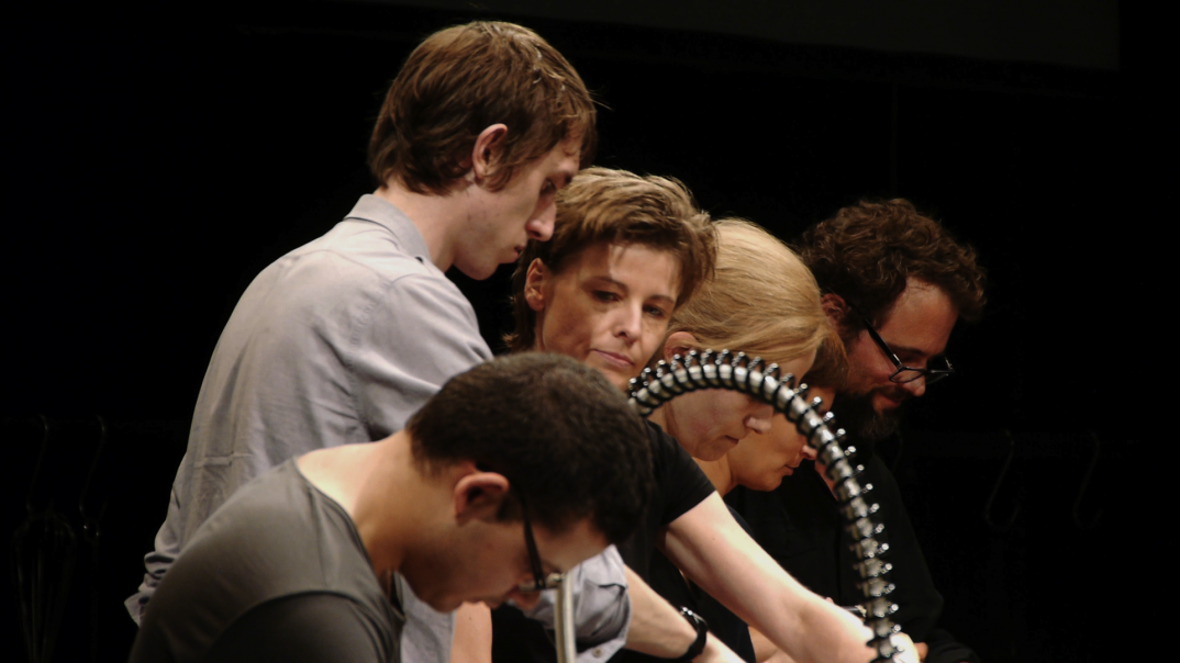 6 people are standing next to each other and looking in different directions. 